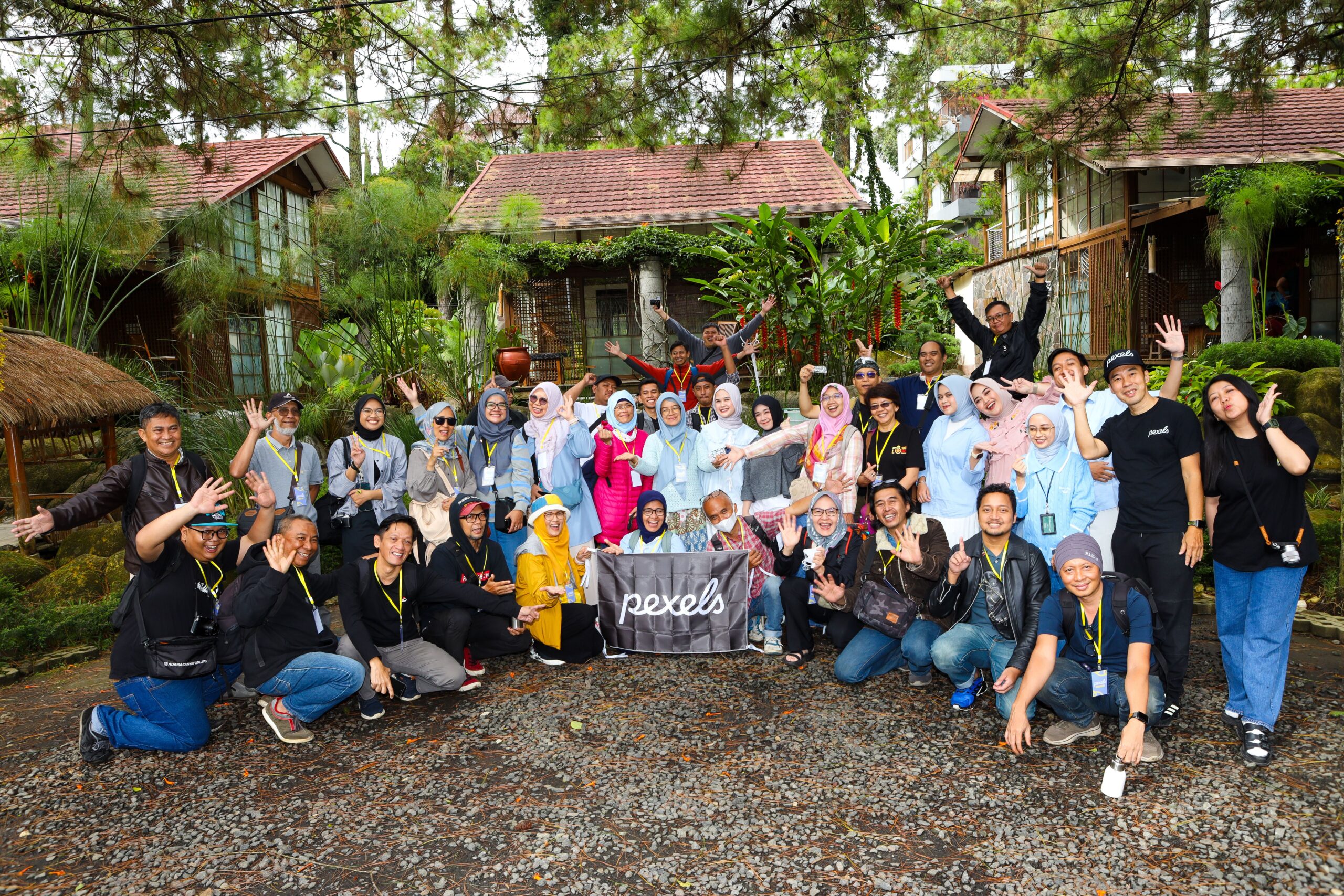 A large group of diverse people pose together for a fun photo outdoors in Jawa Barat, Indonesia.